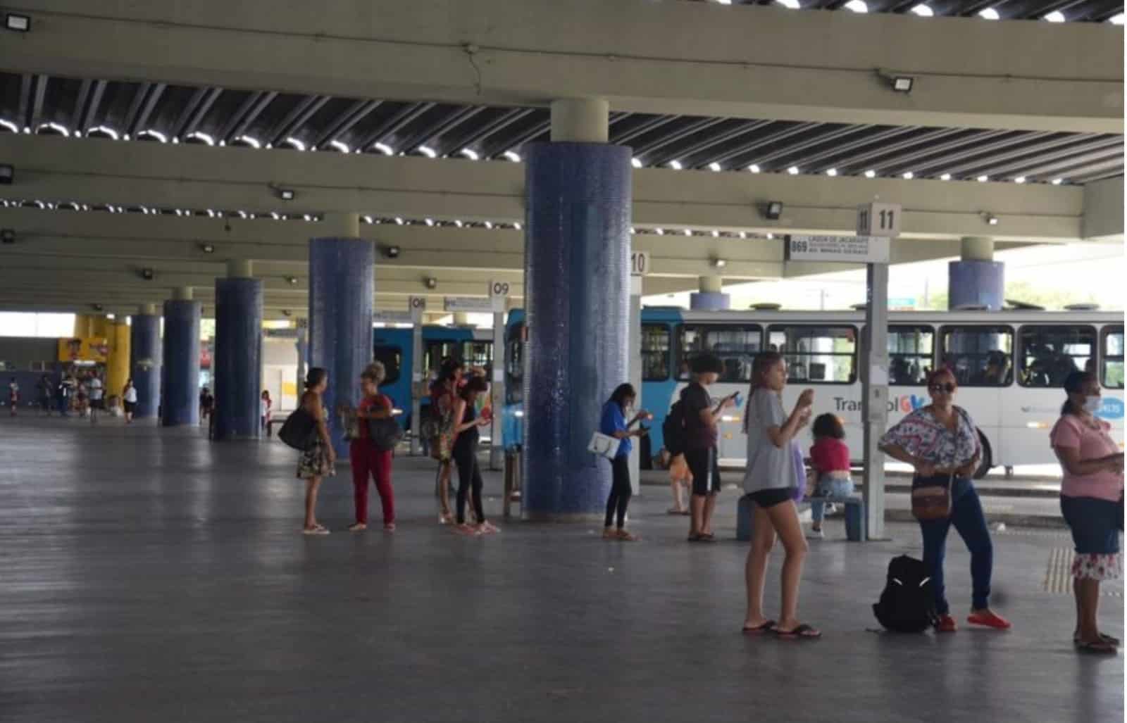 Passageiro encostando o cartão azul de transporte no validador eletrônico dentro do ônibus Transcol em Vitória.