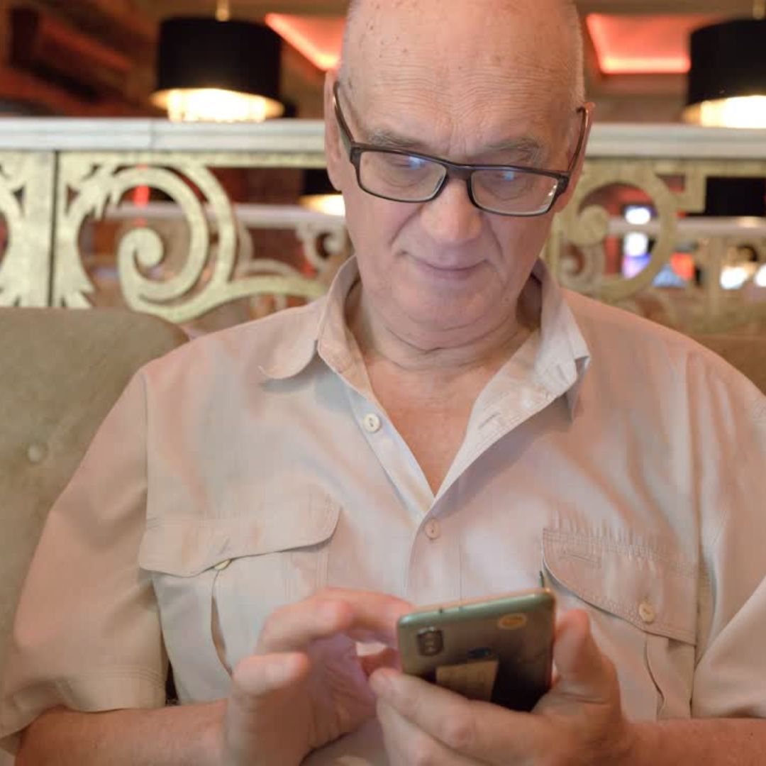 Senhor realizando o reconhecimento de biometria facial no celular para evitar erros de inconsistência no Meu INSS.