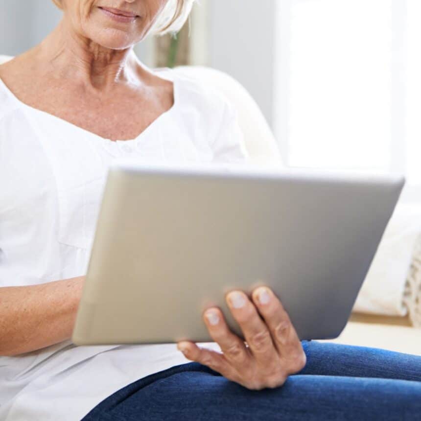 Idoso consultando documentos para isenção de imposto de renda no computador.