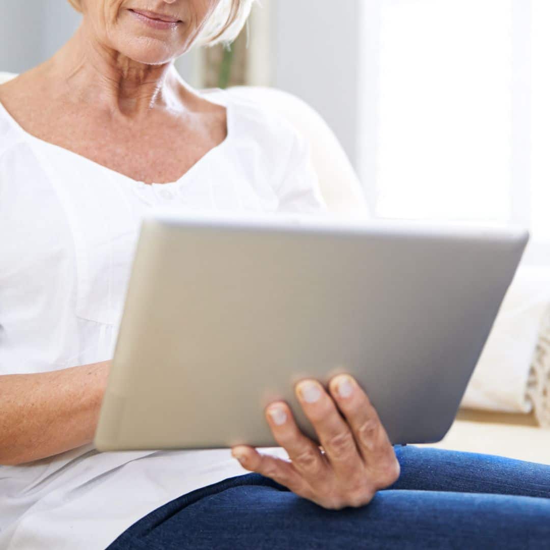 Idoso consultando documentos para isenção de imposto de renda no computador.