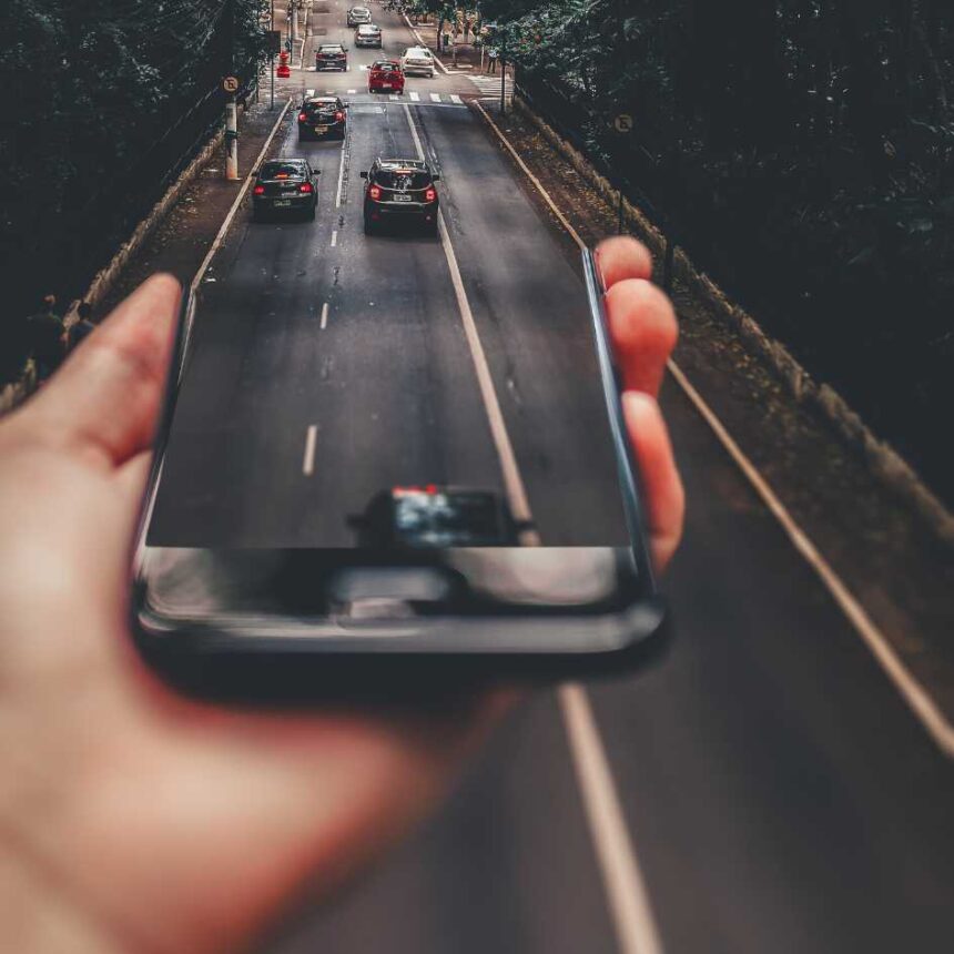 Mão segurando celular mostrando transição de edição para o mundo real sobre como tirar o áudio de um vídeo.
