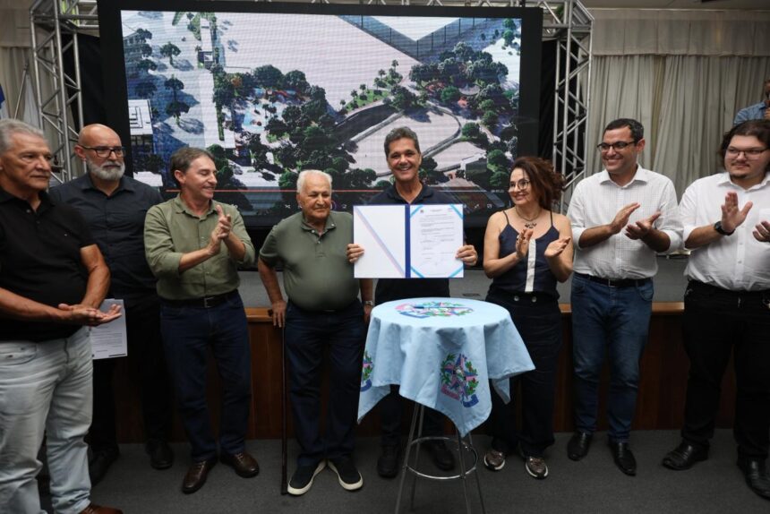 Ricardo Ferraço assina documento de investimento para a Economia no Sul do ES, com painel da obra ao fundo e autoridades presentes.
