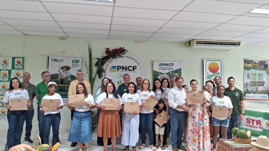 Família agricultora sorrindo ao receber escritura de terra em Colatina.