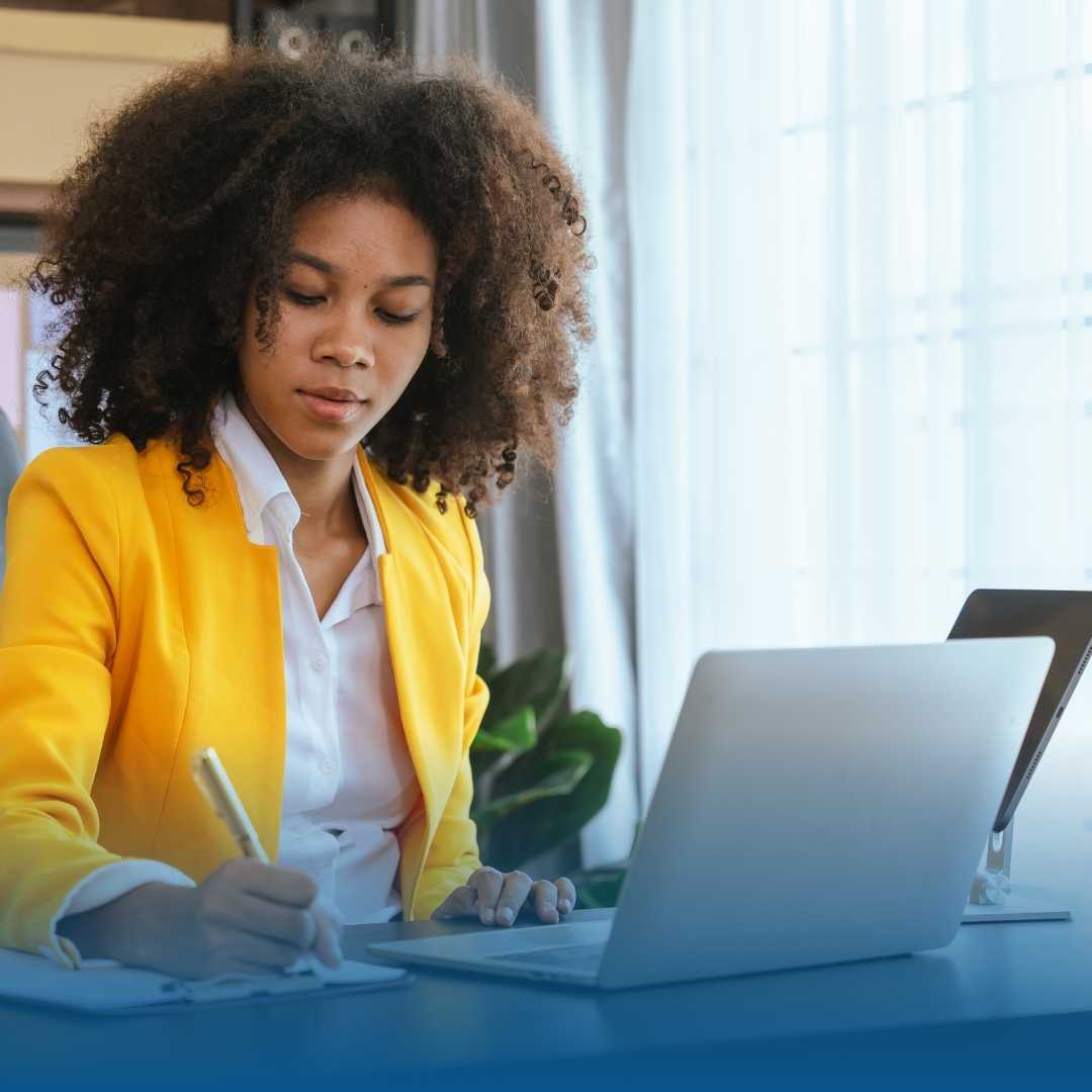 "Mulher jovem com aparência profissional de contadora, sentada em frente a um computador em um escritório organizado. Ela demonstra foco e segurança ao analisar dados na tela, representando o suporte profissional para a declaração do Imposto de Renda."