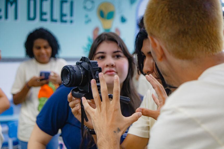 Cine.Ema Itinerante em Cachoeiro de Itapemirim: Alunos assistindo a filme ambiental em tela de projeção dentro de escola estadual.