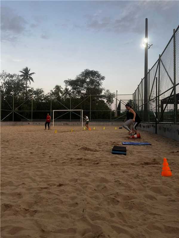 "Registro de moradores participando de atividades e treinos em um campo de futebol durante o retorno do projeto funcional em Alfredo Chaves. Foto mostra pessoas praticando exercícios de força e mobilidade ao ar livre."