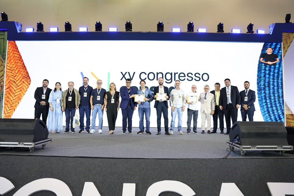 Servidores públicos do Espírito Santo segurando prêmio de gestão pública e inteligência artificial no Consad.
