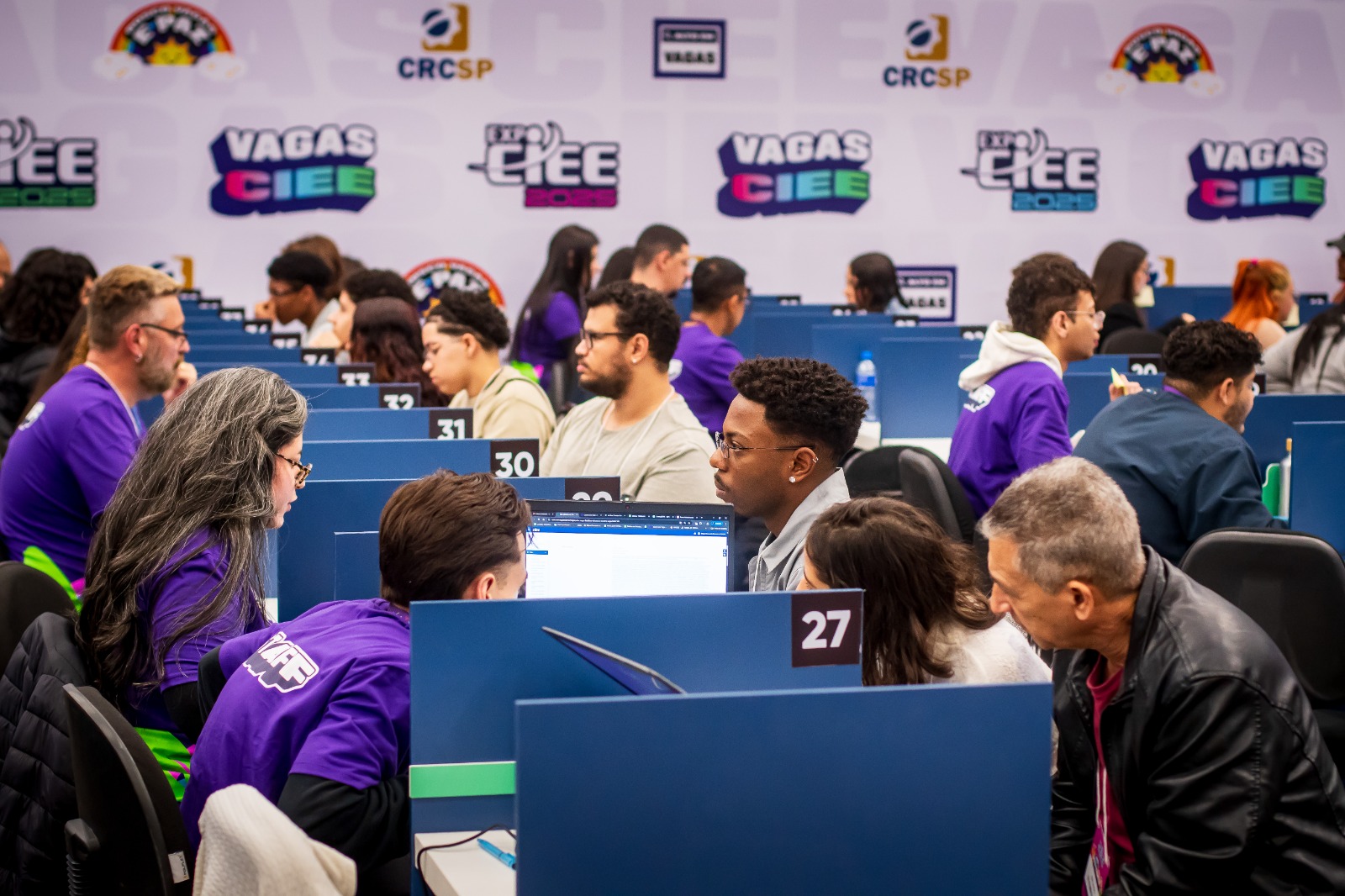 Jovem adolescente sorridente em frente a um computador para participar da maratona de vagas do CIEE.