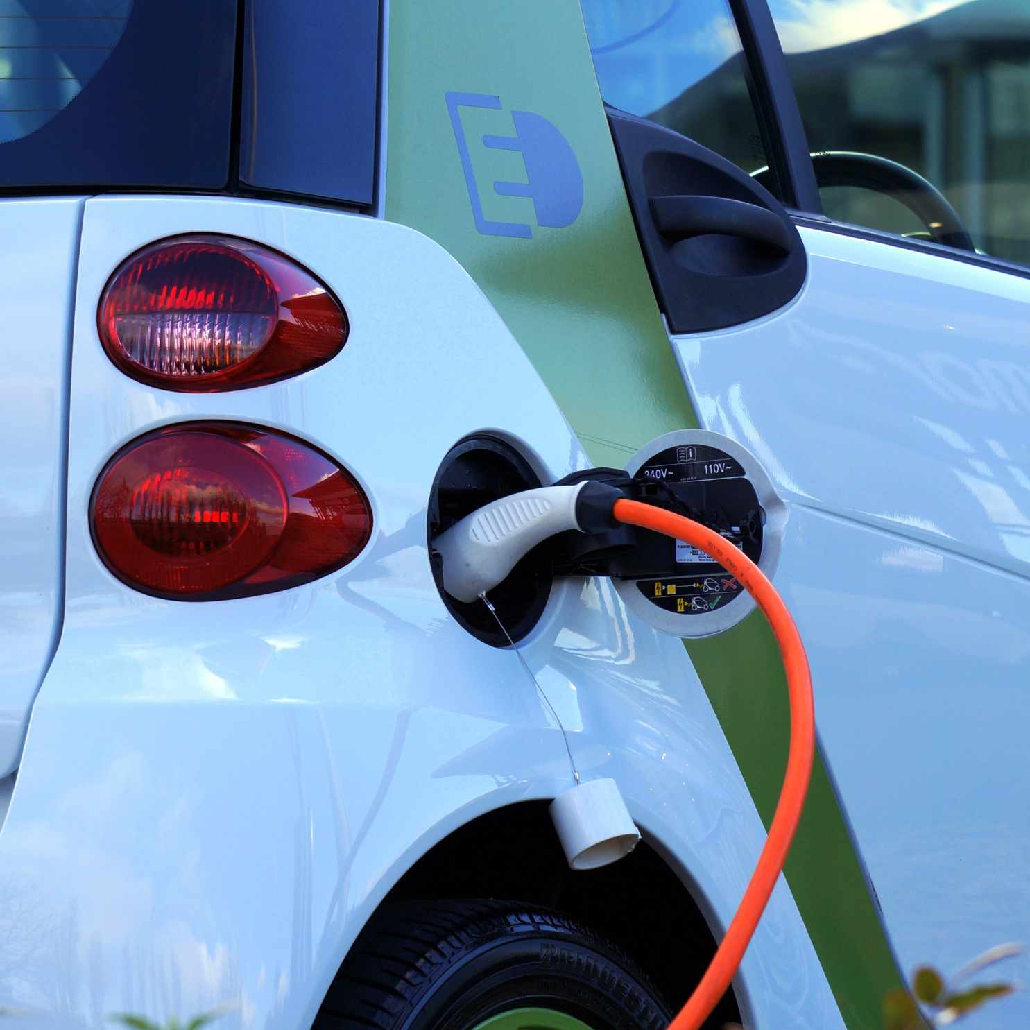 Estação de recarga para carros elétricos instalada em vaga de garagem de condomínio.