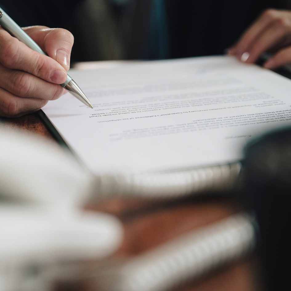 Cliente assinando contrato de compra de imóvel em escritório para posterior registro em cartórios.