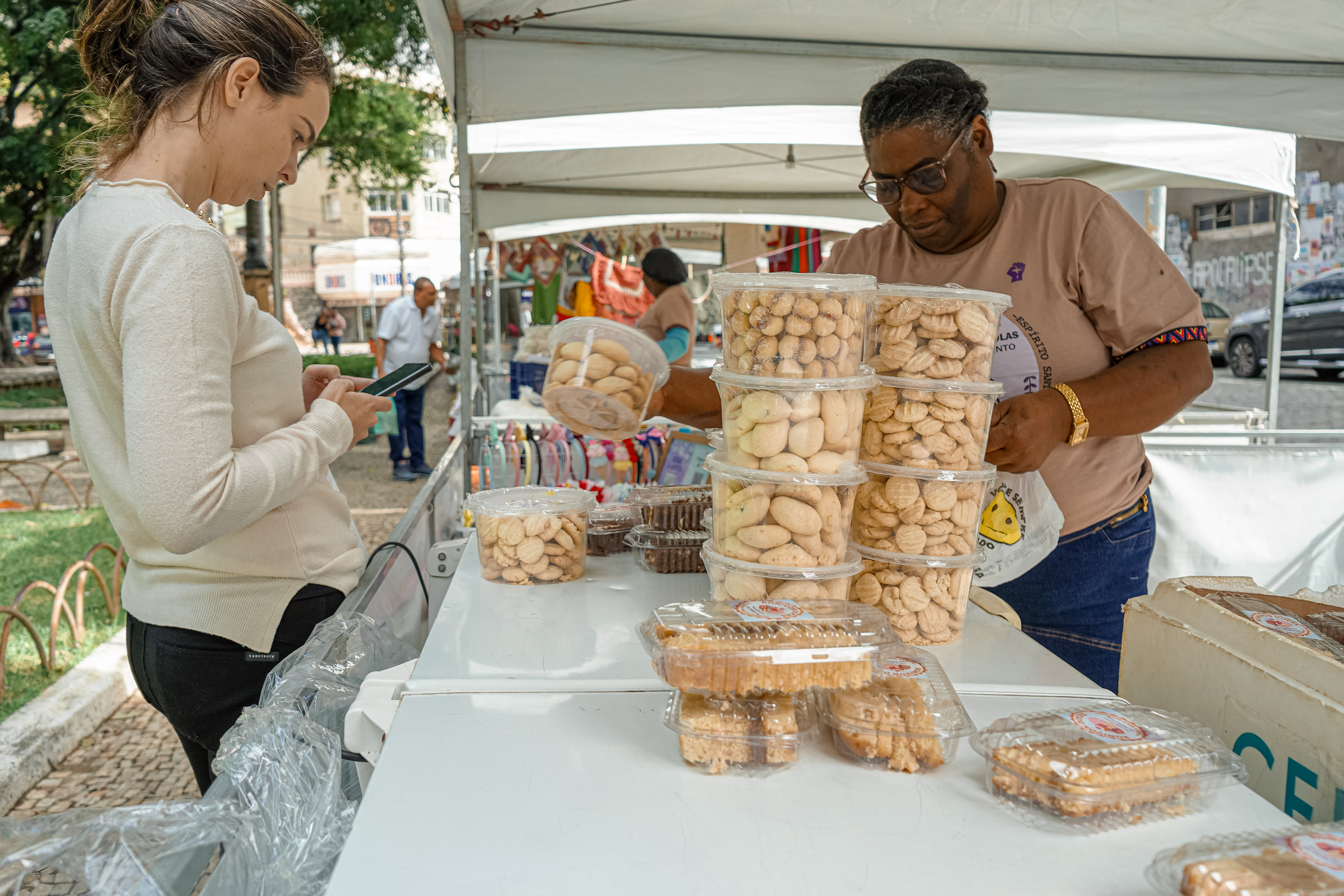 Mulheres quilombolas capixabas organizando estandes de artesanato e culinária típica na Praça Costa Pereira em Vitória, Espírito Santo.