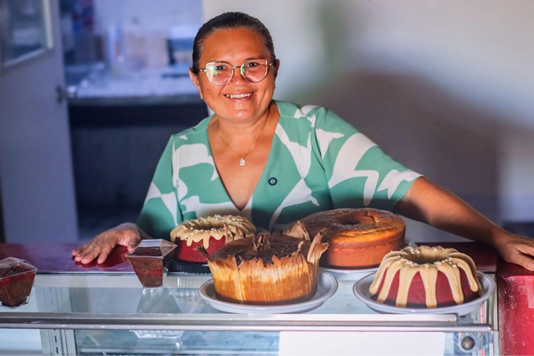 Carteira de trabalho brasileira assinada sobre mesa de escritório, representando a conquista do emprego formal e o aumento de renda das famílias.