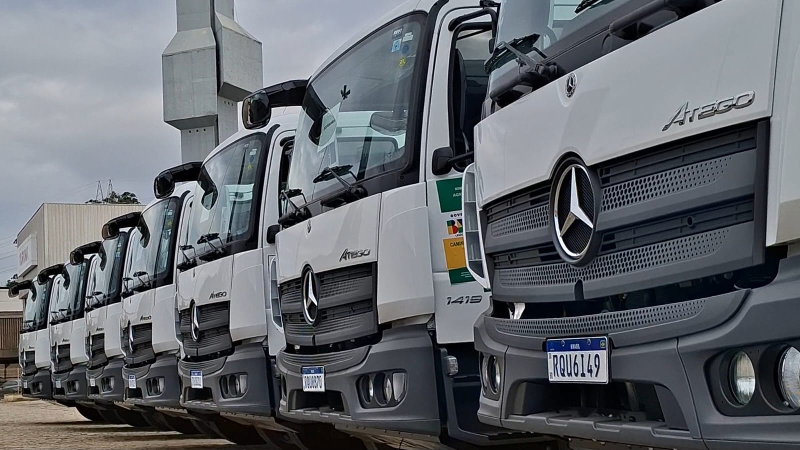 Fileira de caminhões-pipa brancos novos estacionados durante cerimônia de entrega da Seag no Espírito Santo.