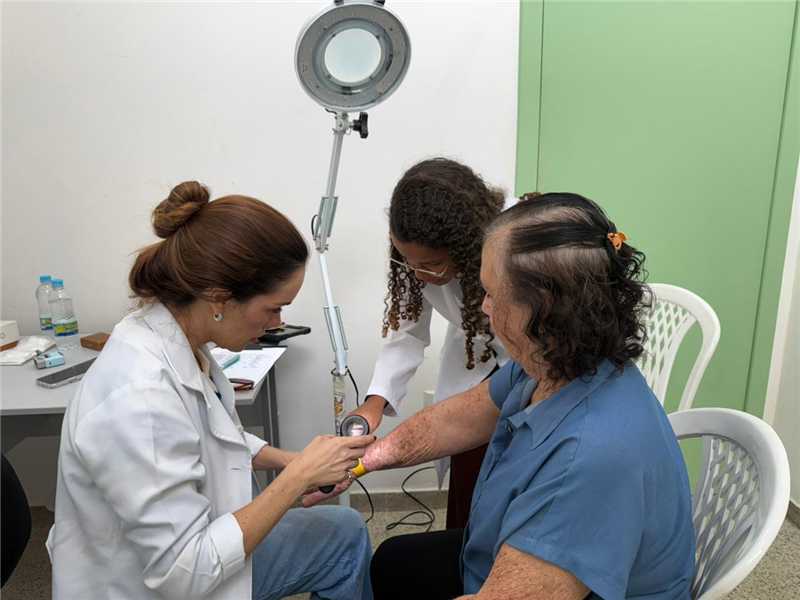 Profissionais de saúde realizando procedimentos preventivos contra o câncer de pele.