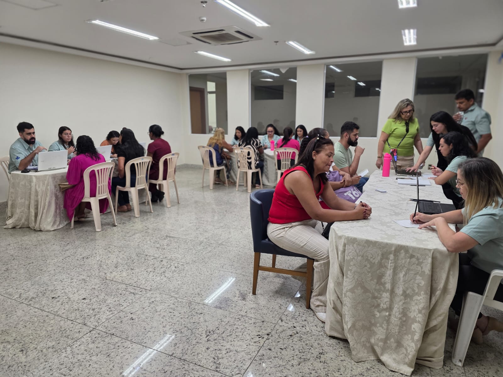 Profissionais trabalhando na recepção de uma unidade de saúde filantrópica com foco na palavra Vagas.