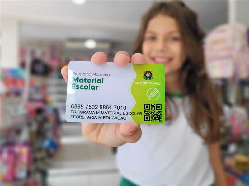 Visão aproximada de materiais escolares diversos organizados sobre uma mesa de madeira escolar com foco nítido.
