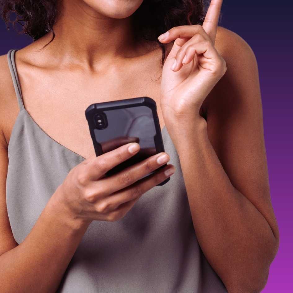 Mulher segurando celular para efetuar denúncia de violência contra a mulher por meio dos canais oficiais de segurança.