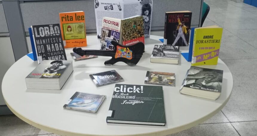 Interior organizado com livros e painéis históricos da Biblioteca Pública do Espírito Santo em Vitória.