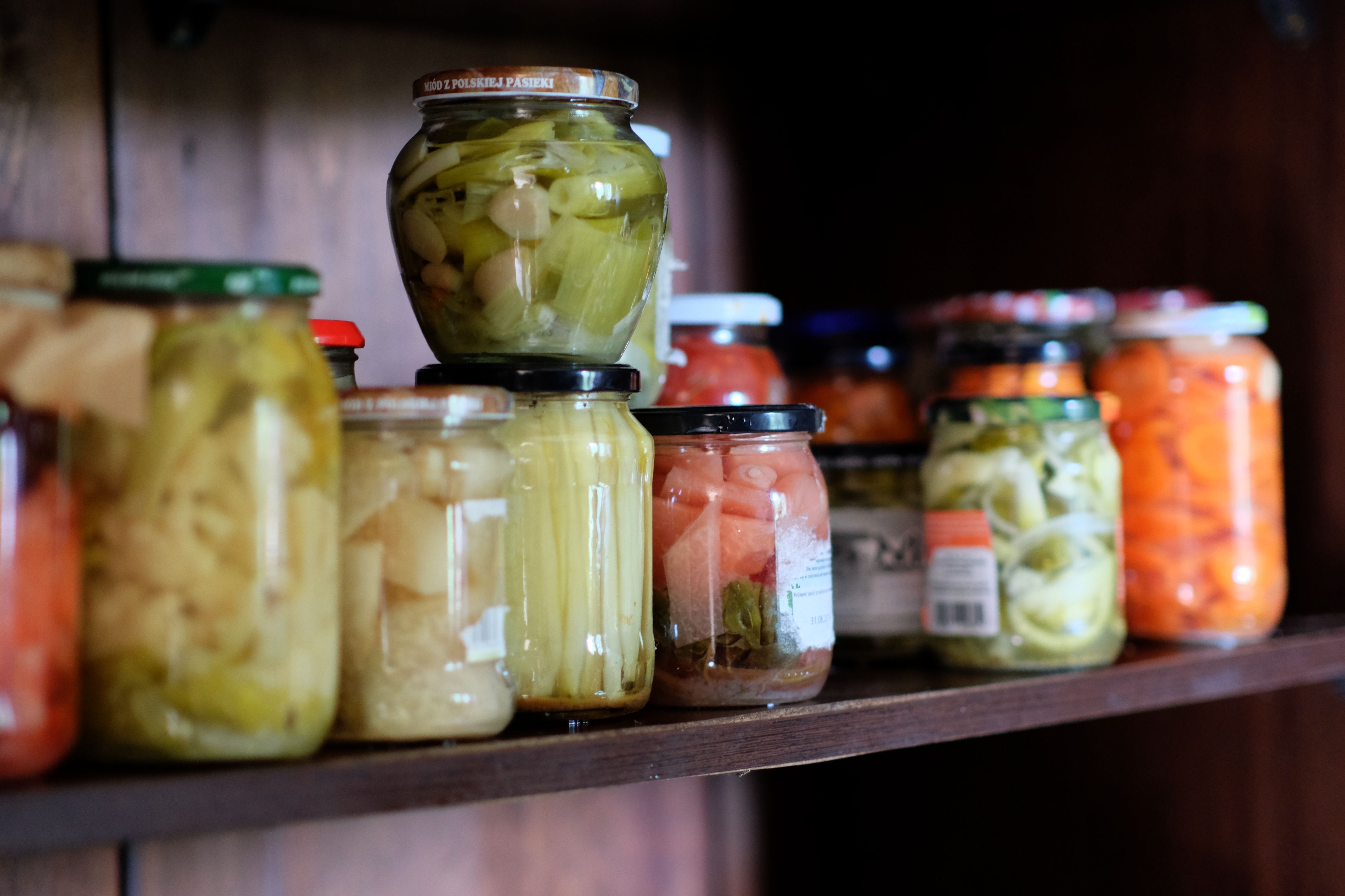 Potes de vidro com legumes em conserva focando o curso gratuito de produção de conservas vegetais em Cariacica.