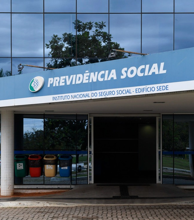 Trabalhador consultando os direitos por Esgotamento Profissional INSS pelo celular após sofrer pressão no ambiente de trabalho.