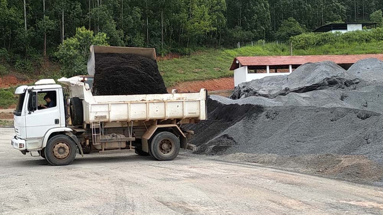 Máquina patrola trabalhando na pavimentação e nivelamento das estradas de Anchieta com revestimento de Revsol.