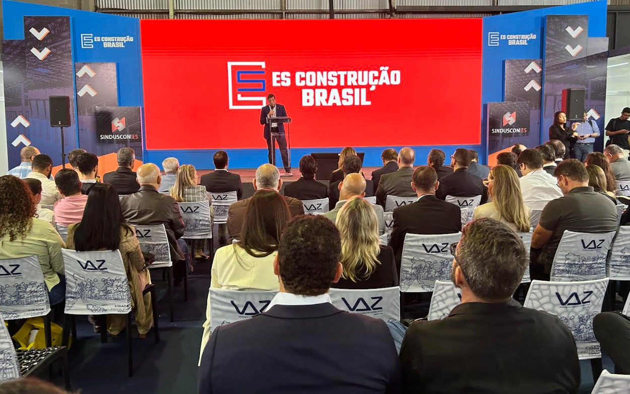 Estande tecnológico da Federação das Indústrias em evento de negócios com público circulando.
