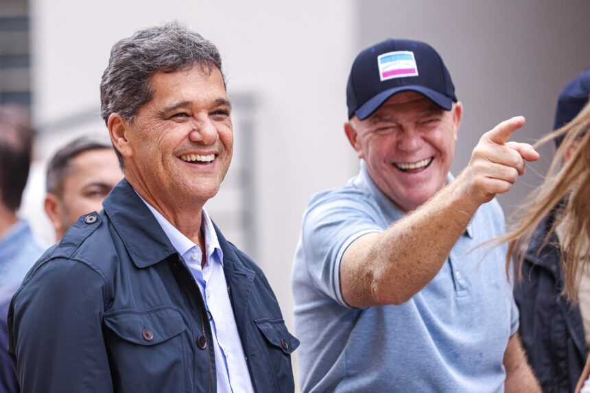 O Governador Ricardo Ferraço ao lado de Renato Casagrande sorrindo e olhando na direção em que Casagrande está apontando.