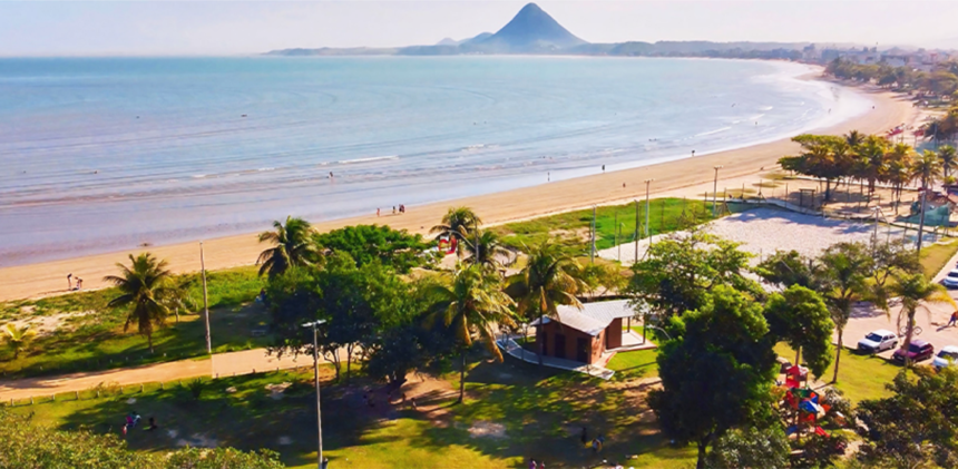 Vista panorâmica da orla costeira e das belezas naturais que cercam a Ilha do Gambá em Piúma sob o céu azul.