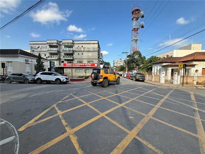 Vista de rua urbana central mostrando o fluxo de trânsito em Alfredo Chaves com carros e sinalização horizontal.