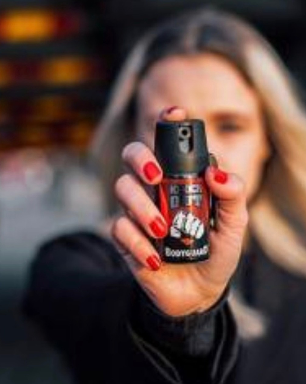 Frasco de spray de pimenta e gengibre para defesa da mulher apoiado sobre uma superfície plana.