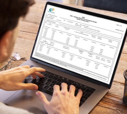 Pessoa realizando o acompanhamento de contribuição do INSS na tela do computador para checar siglas no CNIS.