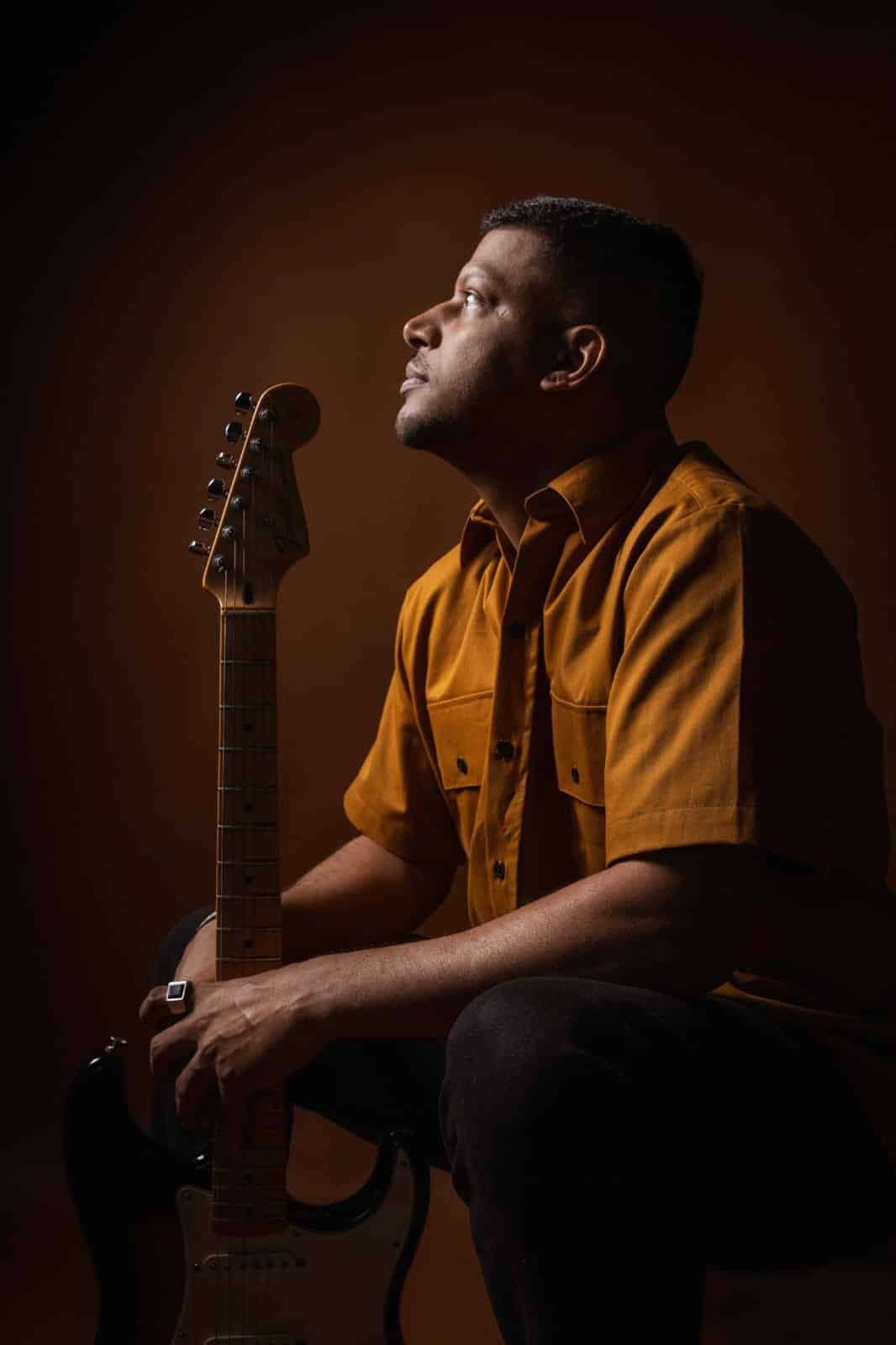Músicos da Escola Gabriel Camargo com violinos no palco e maestro regendo onde a Casa da Música Sônia Cabral anuncia programação pós-feriado.