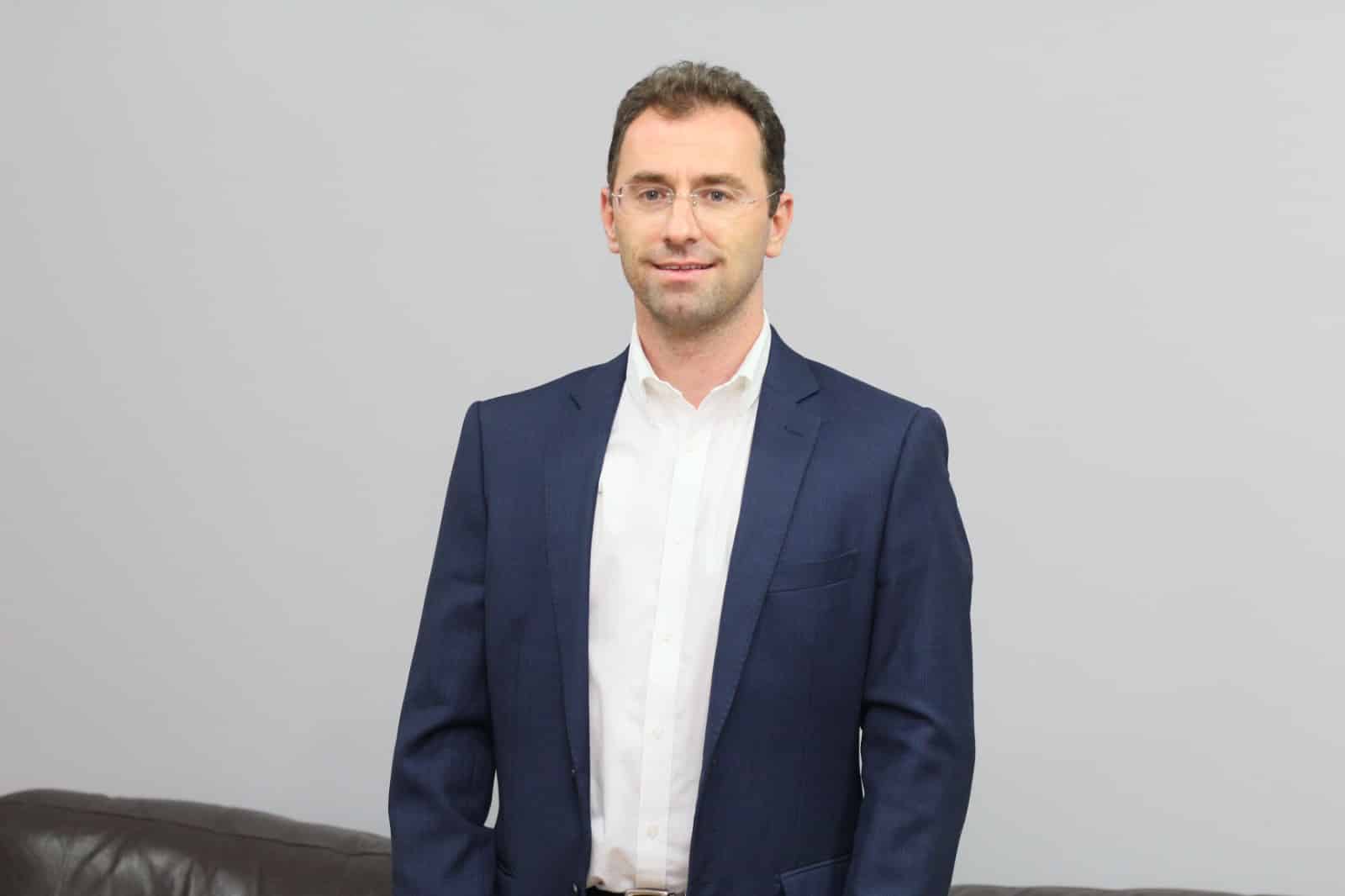 O ex-prefeito de Anchieta Fabrício Petri sorrindo em foto de retrato oficial.