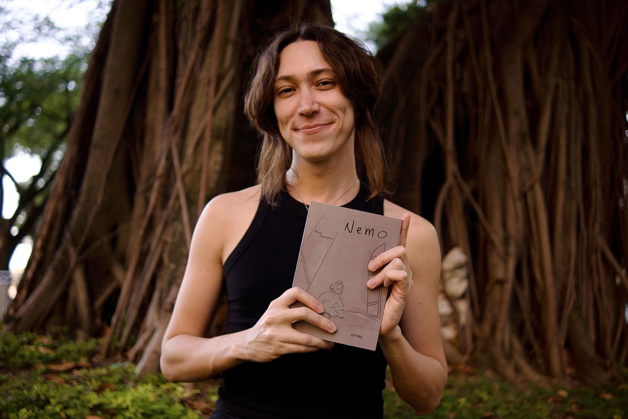 Autora Reya Perovano posando com o livro Nemo para divulgação de oficina sobre literatura infanto-juvenil