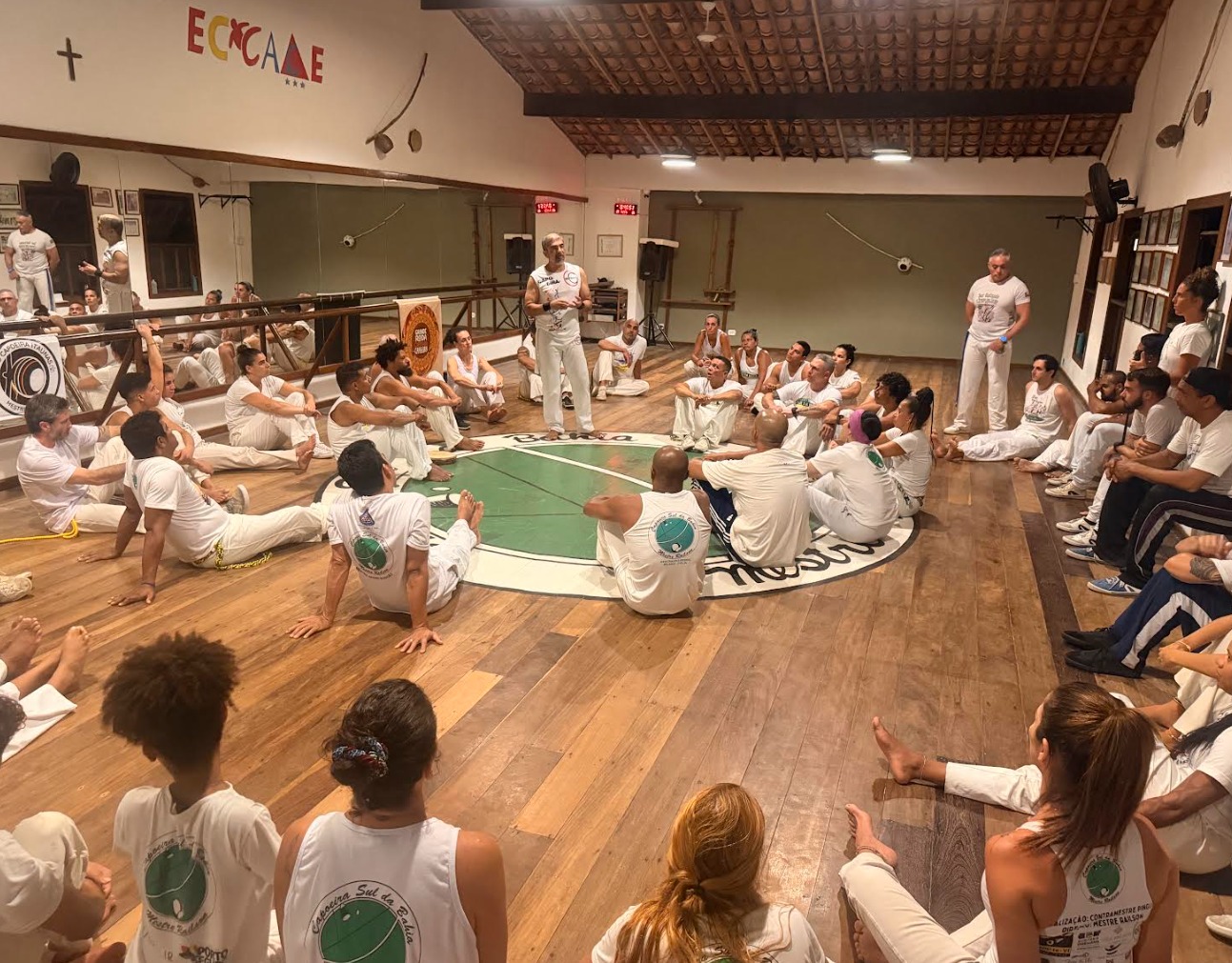 Praticantes participando de roda de capoeira com instrumentos tradicionais durante evento cultural no Espírito Santo.