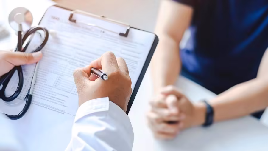 Médico segurando prancheta durante atendimento sobre saúde e regras de consultas.