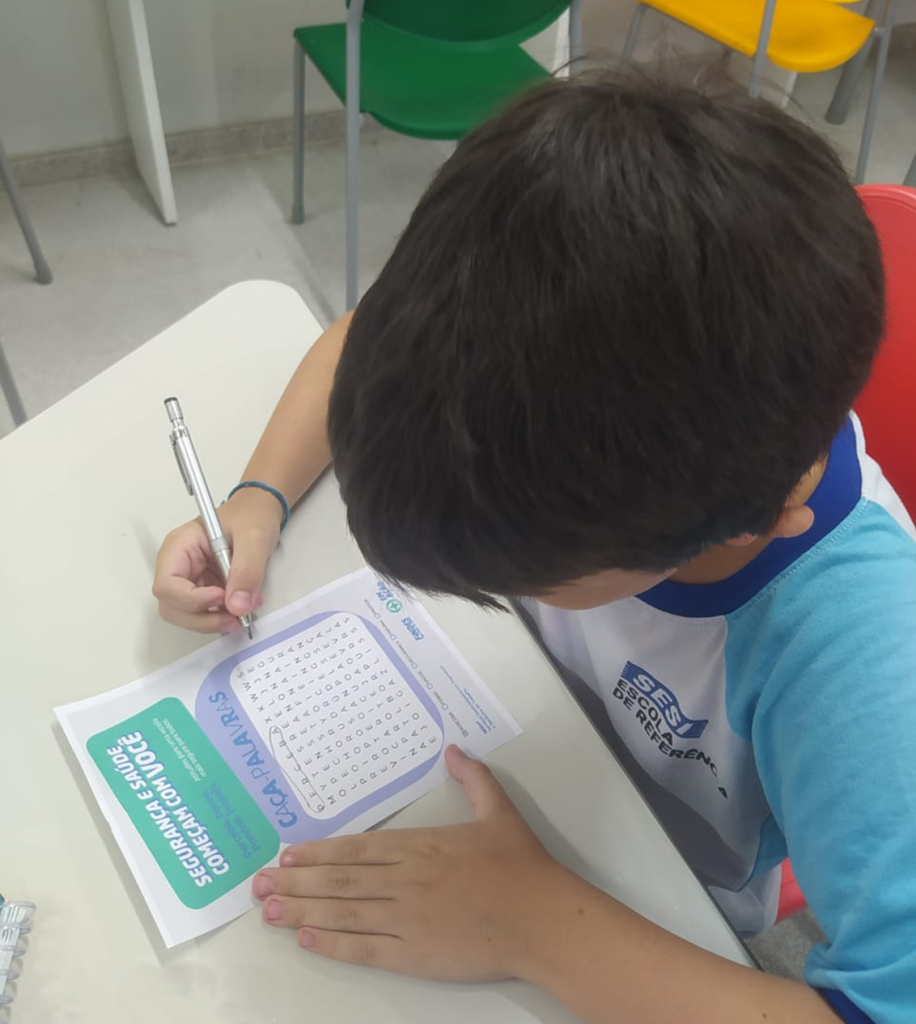 Ações da FINDES no Espírito Santo: crianças em sala de aula do SESI realizando atividade pedagógica sobre segurança.