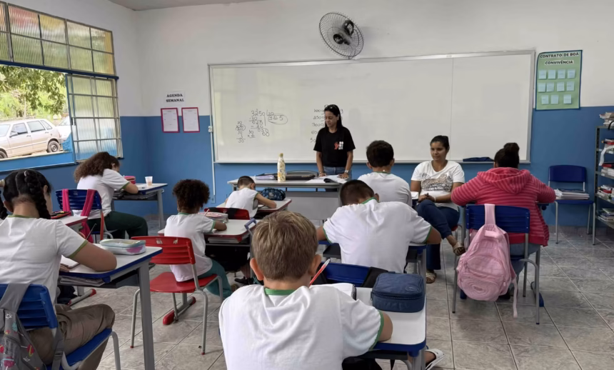 Professora orientando alunos em sala de aula de escola municipal em Alfredo Chaves.